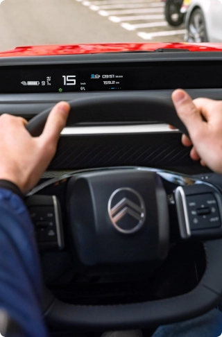 Vue intérieure du poste de conduite de la Citroën ë-C3 Van, mettant en avant le volant multifonction et l’ergonomie orientée conducteur.