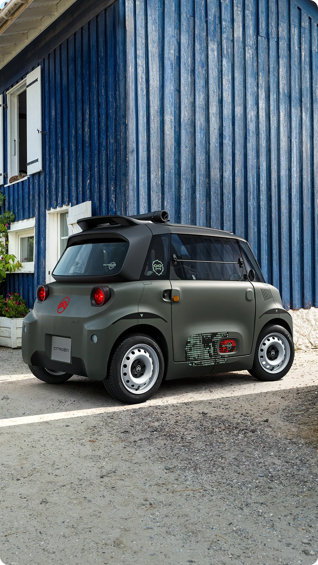 Vue avant de Citroën Ami Outdoor avec phares LED présentant un véhicule urbain électrique ultracompact circulant dans une rue étroite