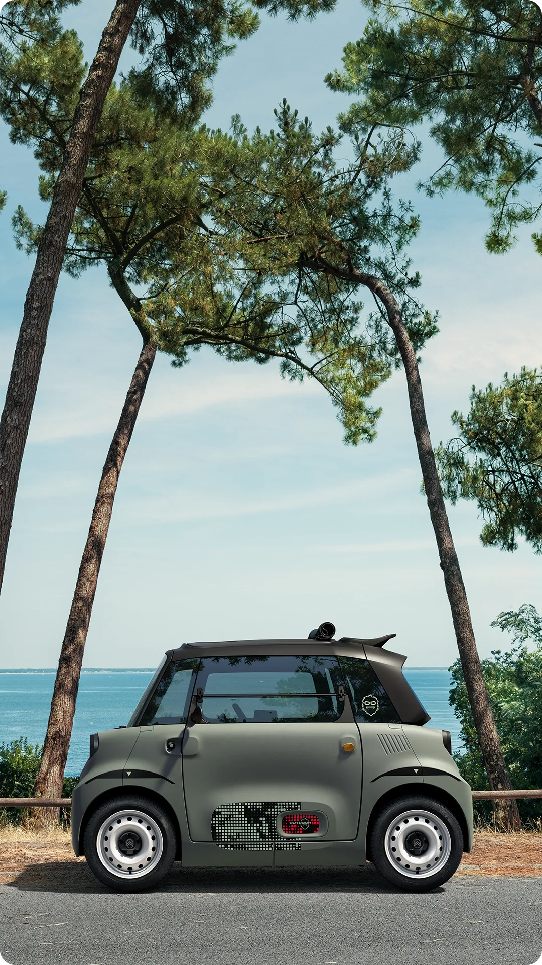 Vue de profil de Citroën Ami Outdoor avec toit ouvert présentant un véhicule urbain électrique sur le littoral pour les déplacements de loisirs