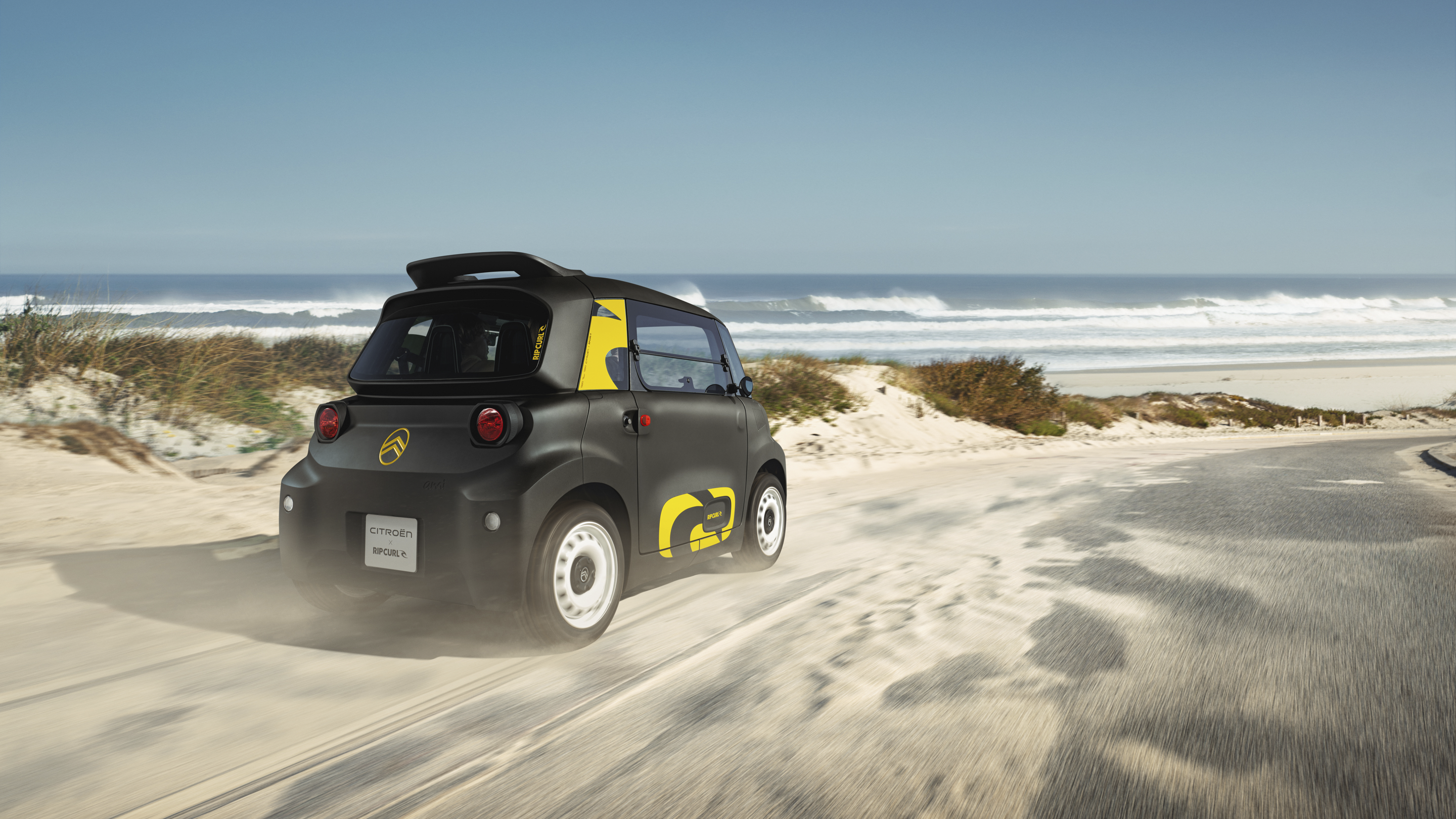 Vue d’action trois‑quarts arrière de la Citroën Ami x Rip Curl électrique sans permis, Citroën Ami synonyme de liberté pour une voiture électrique urbaine