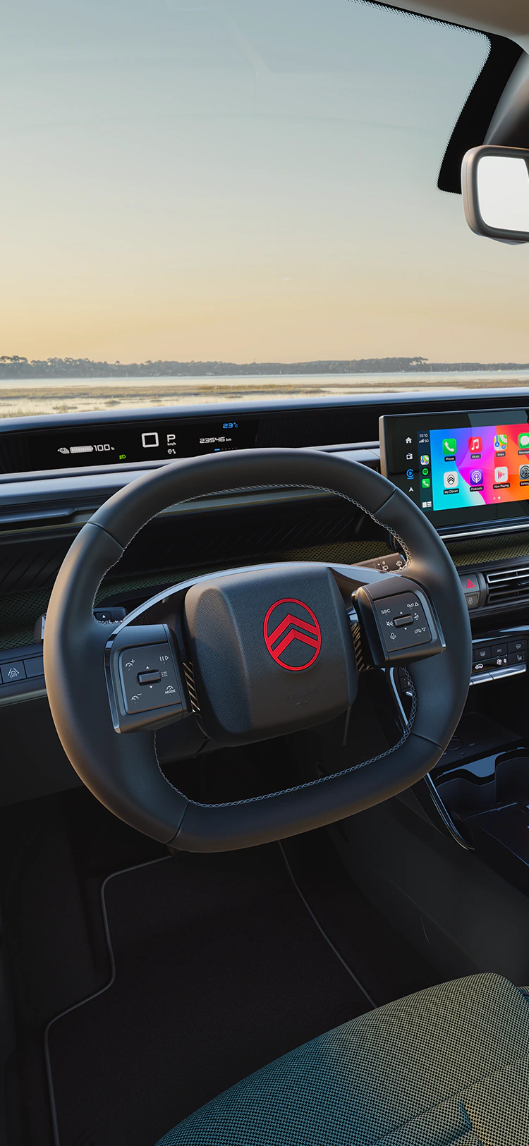 Vue conducteur du tableau de bord de Citroën ë-C3 Outdoor avec écran d’infodivertissement, présentant la connectivité Advanced Comfort pour les trajets en famille en SUV