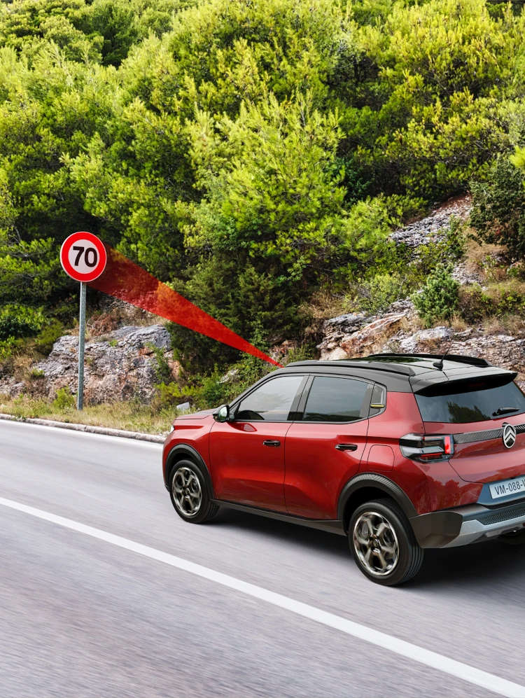 Vue de conduite latérale du SUV électrique Citroën ë-C3 montrant la reconnaissance des limites de vitesse pour une mobilité quotidienne plus sûre, confiante et abordable.