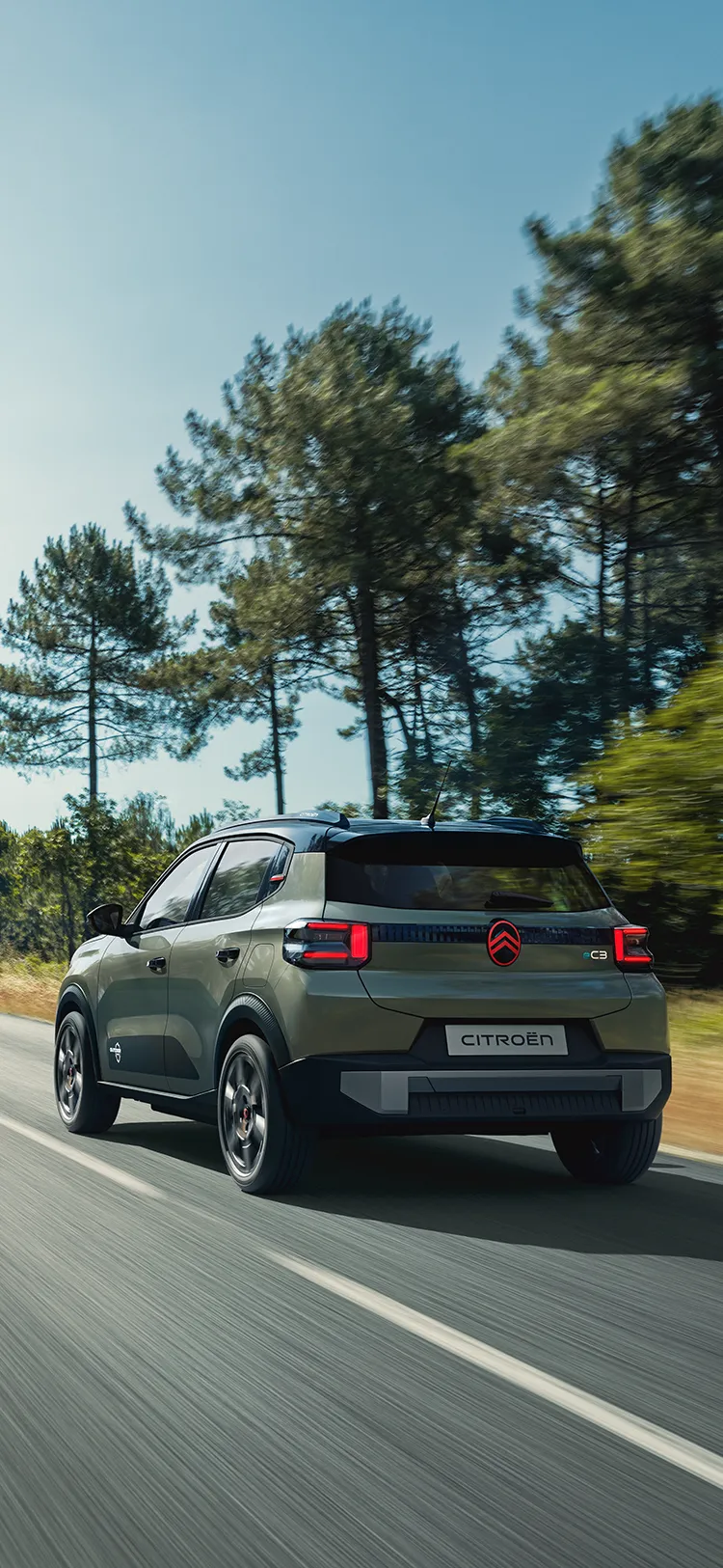 Vue arrière trois-quarts de Citroën ë-C3 Outdoor avec feux arrière LED, présentant un SUV Advanced Comfort sur route ouverte
