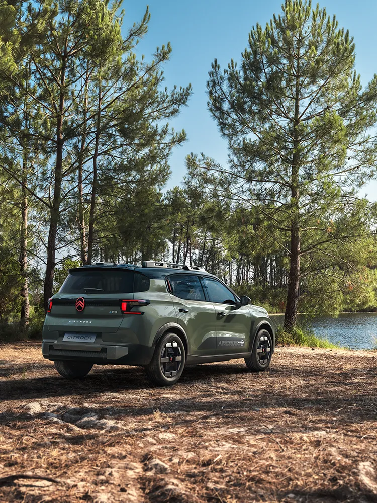 Vue arrière trois-quarts de Citroën C3 Aircross, présentant la signature lumineuse LED et Advanced Comfort d’un SUV familial sur une route forestière