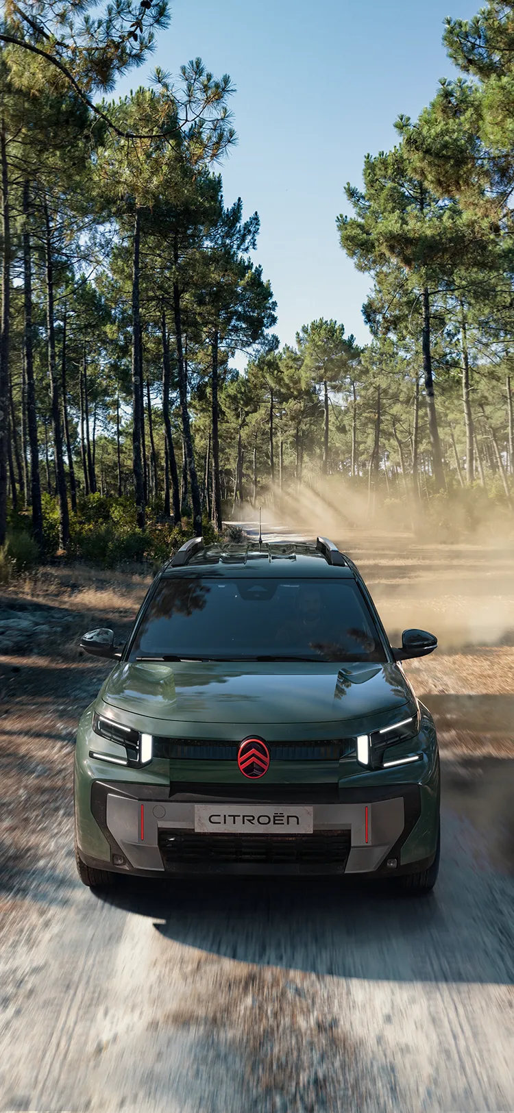 Vue avant aérienne de Citroën C3 Aircross, présentant la signature lumineuse LED et Advanced Comfort d’un SUV familial sur un chemin forestier
