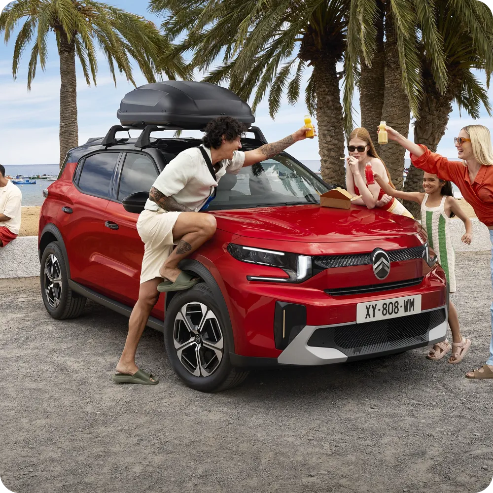 Vue extérieure du SUV Citroën C3 Aircross équipé de barres de toit et de boîte de toit pour une capacité de voyage polyvalente, spacieuse et abordable.