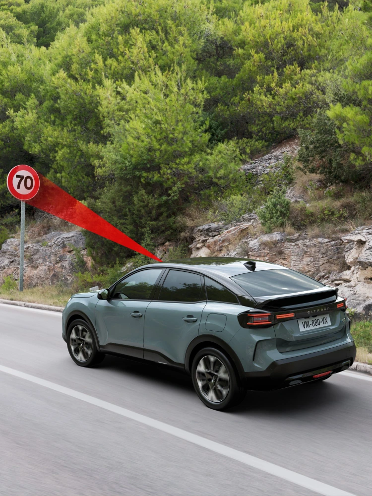 Vue latérale ë-C4 avec reconnaissance des panneaux de signalisation mettant en avant la sécurité, la technologie et la visibilité pour une conduite premium plus sûre