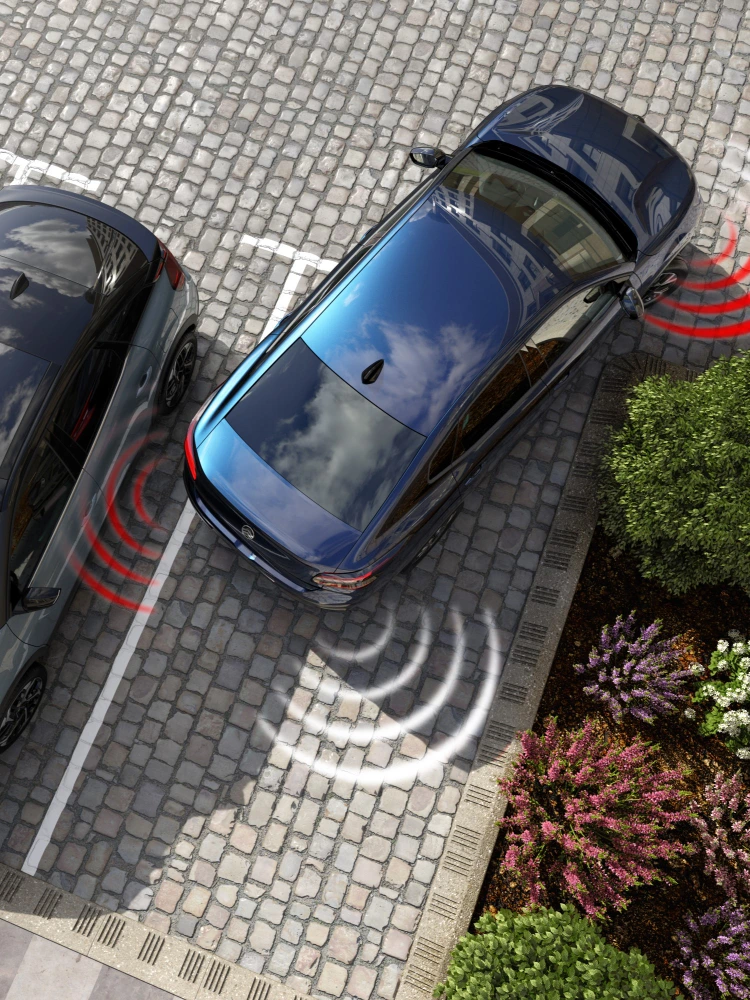 Vue aérienne de la Citroën ë-C4 X montrant des capteurs de stationnement actifs à l’arrière et à l’avant lors des manœuvres