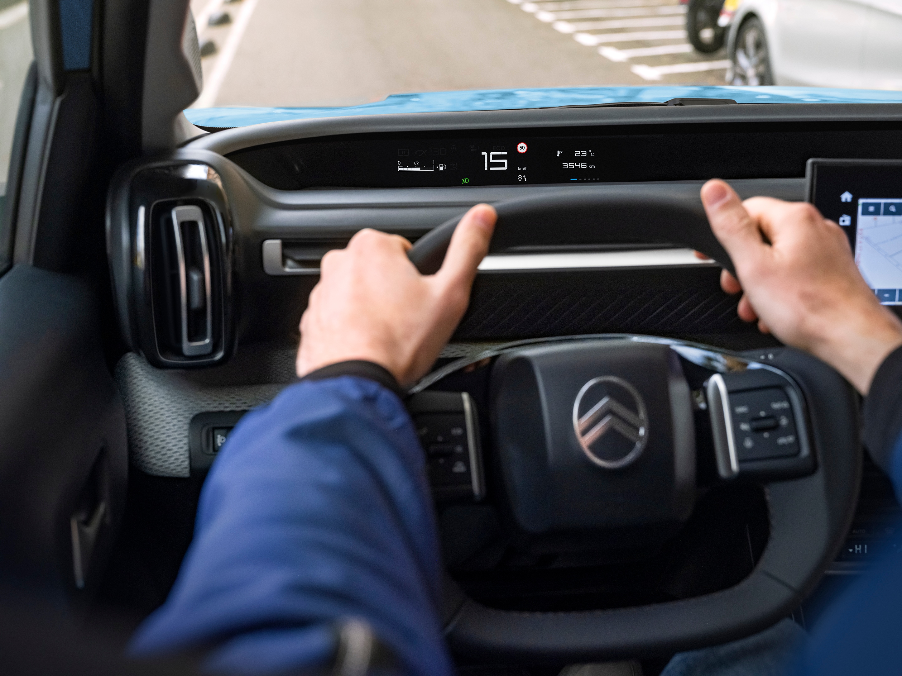 Vue du conducteur depuis le cockpit du SUV électrique Citroën ë-C3, avec un affichage numérique pour une mobilité urbaine intuitive, abordable et confortable.