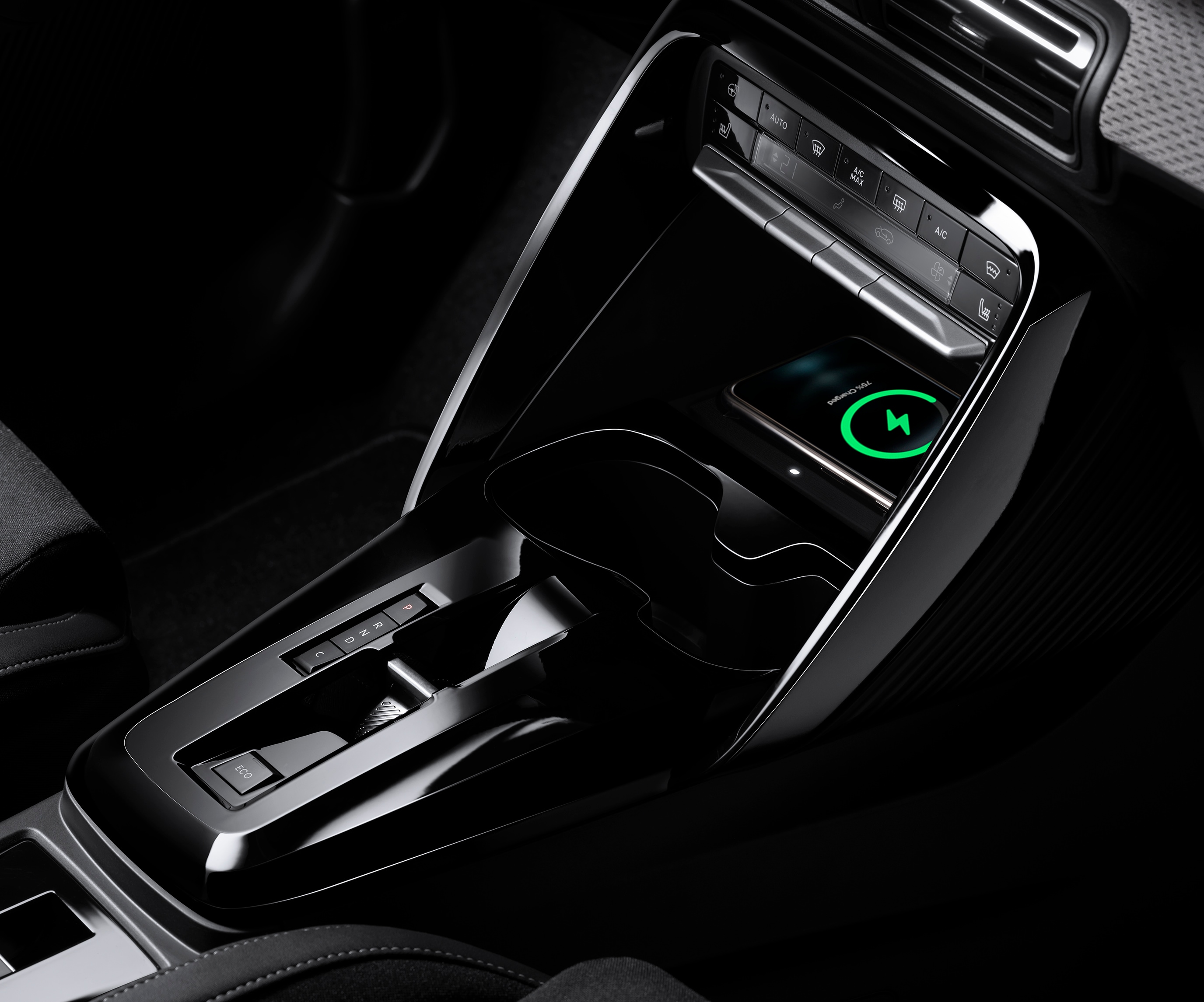 Vue rapprochée de la console Citroën ë-C3 avec une recharge sans fil pour une mobilité quotidienne pratique et abordable.
