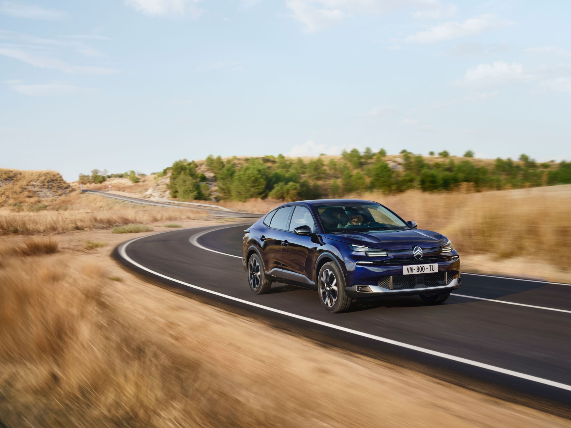 Vue de conduite avant trois quarts de la Citroën ë-C4 X montrant un fastback agile pour une mobilité confiante et abordable