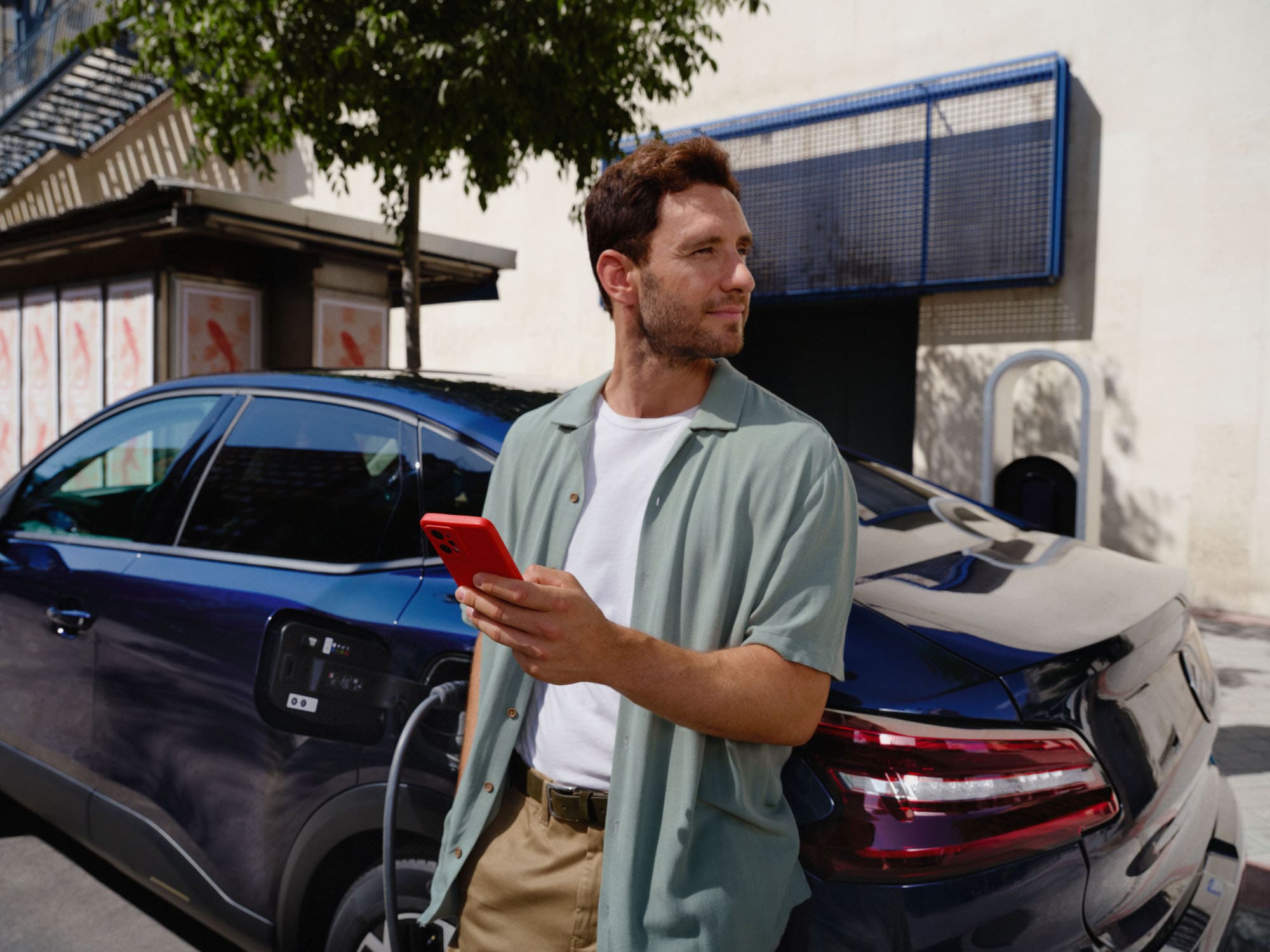 Scène de recharge connectée de la Citroën ë-C4 X fastback montrant l’utilisation d’applications intelligentes pour une mobilité électrique pratique au quotidien
