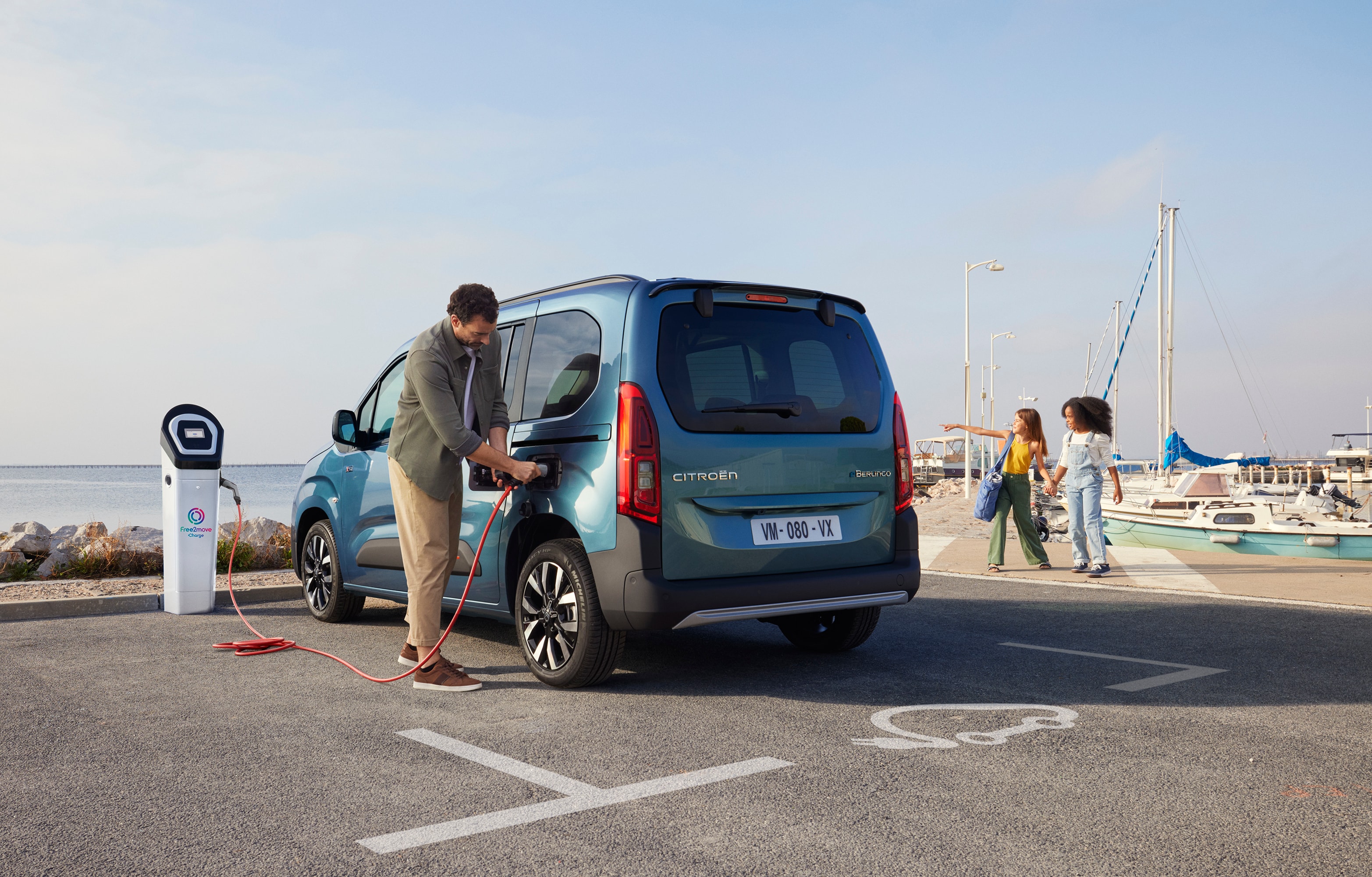 Vue arrière à trois quarts de la Berlingo en charge à une station Free2move, montrant sécurité, efficacité, technologie et utilisation assurée