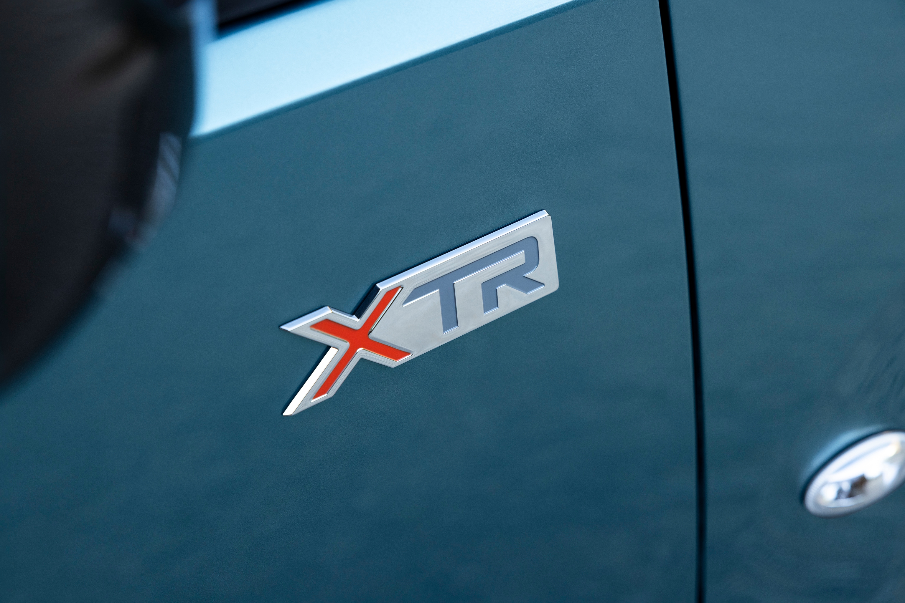 Vue détaillée du badge Berlingo XTR mettant en avant un design distinctif, une qualité, une durabilité et une identité de modèle renforcée
